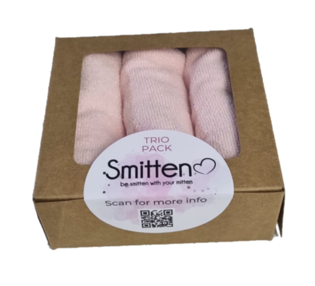 Box of pink knitted items with 'Smitten' label on a white background
